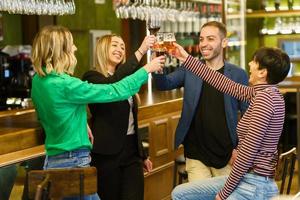 Optimistic friends proposing toast in a pub