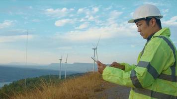 a man engineer is wearing a protective helmet on her head, using tablet Analytics engineering data. video