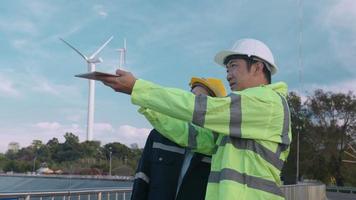 el ingeniero de personas lleva un casco protector en la cabeza, utilizando datos de ingeniería de análisis de tabletas. video