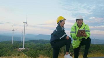 el ingeniero de personas lleva un casco protector en la cabeza, utilizando datos de ingeniería de análisis de tabletas. video