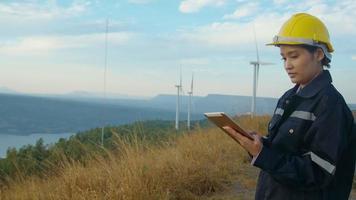 a woman engineer is wearing a protective helmet on her head, using tablet Analytics engineering data. video