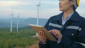 a woman engineer is wearing a protective helmet on her head, using tablet Analytics engineering data. video