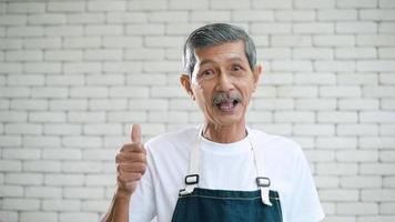 retrato de un anciano jubilado asiático feliz en el jardín de su casa. video