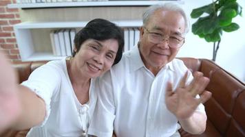 um idoso feliz asiático idoso faz videochamadas, relaxa em casa, sorrindo avós aposentados idosos saudáveis, conceito de tecnologia de avós mais velhos. video
