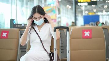 une voyageuse porte un masque de protection à l'aéroport international, voyage sous la pandémie de covid-19, voyage en toute sécurité, protocole de distanciation sociale, nouveau concept de voyage normal. video