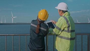 l'ingegnere delle persone indossa un casco protettivo sulla testa, utilizzando i dati ingegneristici di analisi del tablet. video