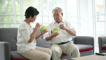 una pareja de ancianos está comiendo alimentos saludables , el concepto de atención médica de los abuelos . video