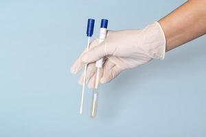 Test for coronavirus in the doctors hand on a blue background. Medical concept, closeup photo