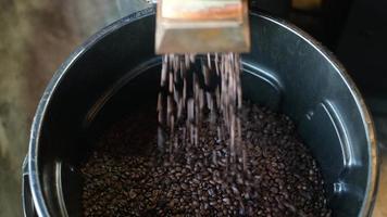 el grano de café se está asando en la máquina tostadora, fumando del café. video