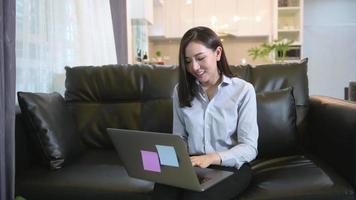een zakenvrouw werkt met een laptopcomputer en analyseert bedrijfsgroeigrafiekgegevens in de woonkamer, werk vanuit huis, bedrijfstechnologieconcept. video
