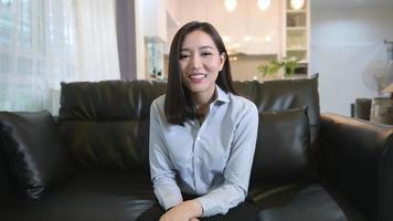 Headshot screen view of  young asian woman is using laptop computer to Video calling or Webcam to greeting her family , telecommunications technology , parenthood family concept