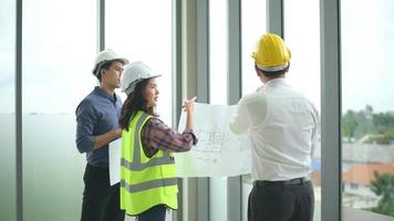 les ingénieurs sont des plans de construction analytiques avec un plan directeur au bureau. video