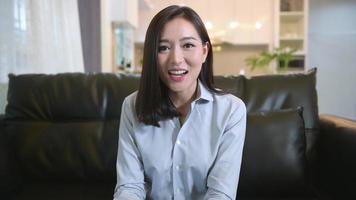 Headshot screen view of  young asian woman is using laptop computer to Video calling or Webcam to greeting her family , telecommunications technology , parenthood family concept