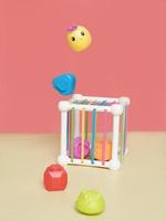 baby educational toy. a multi-colored cube. Development of fine motor skills and logical thinking, levitating pieces of a toy, red background photo