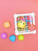 top view of kids educational toy, colorful cube with details for skills developing and brain boost. montessory method. red background photo