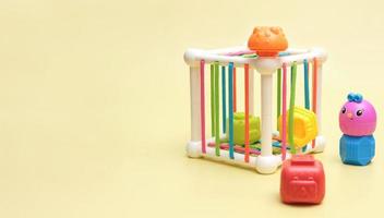 baby educational toy - a multi-colored cube. Development of fine motor skills and logical thinking. stacking pieces of a toy, copy space photo