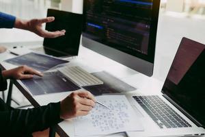 Professional development programmer cooperating meeting programming website working a software in office room. photo