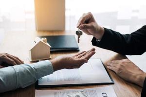 Home agents are handing out keys to home buyers who are signing contracts at the office. photo