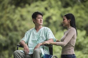 Disabled man in wheelchair and girlfriend in the park photo