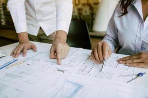 Engineering man showing blueprint detail for people buying house. photo