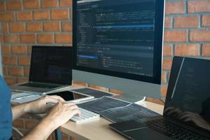 Asian man working code program developer computer web development working design software on desk in office. photo