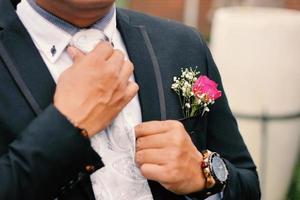 The groom tightens his cufflinks before the wedding photo