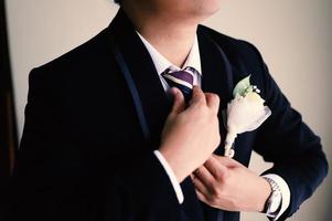 The groom tightens his cufflinks before the wedding photo