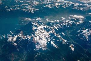 la vista desde el avión sobre las cimas nevadas de las montañas alpinas foto