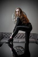 Girl and time. Beautiful young girl posing against the background of a wall clock photo