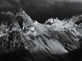 Terrible lifeless rocks, a glacier in the Alps, clouds and fog spread over the peaks of the mountains photo