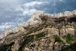 Terrible lifeless rocks, a glacier in the Alps, clouds and fog spread over the peaks of the mountains photo