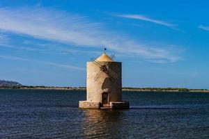 Old windmill in italy, tuscany. Standing in the water photo