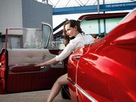 60-s oldtimer red Cadillac and a beautiful young girl photo