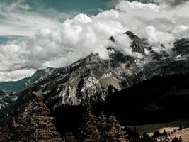 terribles rocas sin vida, un glaciar en los Alpes, nubes y niebla esparcidas sobre los picos de las montañas foto