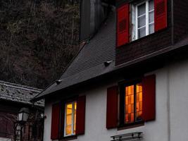 resplandecientes y cálidas ventanas hogareñas en un pequeño pueblo alsaciano. comodidad y calidez en casa en una noche de invierno. foto
