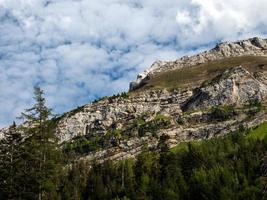 Terrible lifeless rocks, a glacier in the Alps, clouds and fog spread over the peaks of the mountains photo