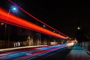 vista nocturna del rastro de las luces del autobús en la carretera de la ciudad, estrasburgo, francia foto