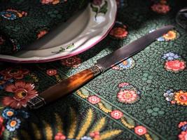 A simple but elegant tablecloth and cutlery laid out on it. Crystal glasses in the sun. Everything is ready for lunch in the garden. photo