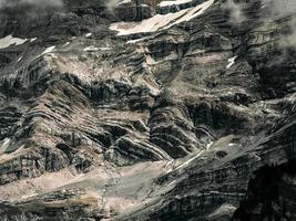 terribles rocas sin vida, un glaciar en los Alpes, nubes y niebla esparcidas sobre los picos de las montañas foto