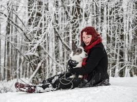 Portrait of a girl in the snow with her pet - corgi. photo