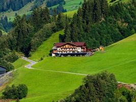 colinas verdes de un resort alpino en austria en verano. pequeño pueblo, hoteles y chalets, todo en colores. hermosas terrazas y paneles solares en los techos. la proximidad de la civilización y la naturaleza pura. foto