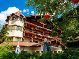 colinas verdes de un resort alpino en austria en verano. pequeño pueblo, hoteles y chalets, todo en colores. hermosas terrazas y paneles solares en los techos. la proximidad de la civilización y la naturaleza pura. foto
