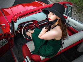 Old-timer red Cadillac and a beautiful young girl photo