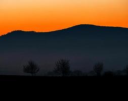 siluetas de montañas y colorida puesta de sol increíble en alsacia foto