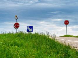 Crossroads of asphalt roads in a clean floor. Green grass and road signs photo