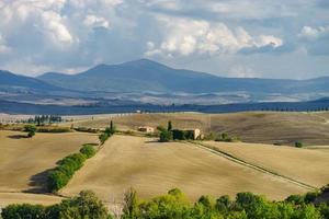 Villa in Italy, old farmhouse in the waves of tuscanian fields and hills photo