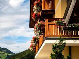 Potted flowers on balconies and terraces of wooden Austrian chalets in the small village of Grossarl. Classical tourism to Austria. Beauty, comfort and harmony. Clean air and quiet life in the Alps. photo