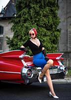 Old-timer red Cadillac and a beautiful young girl photo
