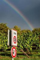Speed sign 30 in vineyards with rainbow on background photo