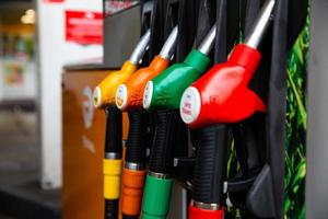 Close up on fuel nozzle in oil dispenser with gasoline and diesel in service gas station. photo